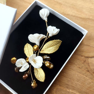 Petit bijou floral avec perles naturelles keshi bronze doré, fleurs nacrées et feuilles dorées en porcelaine froide pour coiffure de mariage ou soirée chic.
