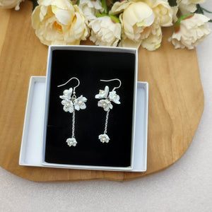Boucles d'oreilles romantiques avec 3 plus grandes fleurs blanches et 1 petite pendante sur chaîne agrémentées de perles pour mariage romantique bohème ou champêtre-chic