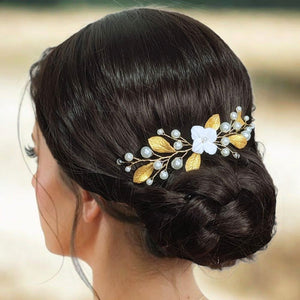 Vigne de cheveux courte avec perles nacrées, fleur blanche et feuilles dorées en porcelaine froide pour arrière tête ou chignon de mariage