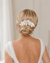 Charger l'image dans la galerie, Vue plus large d’une mariée blonde portant un peigne à feuilles blanches en porcelaine sur un chignon bas romantique.