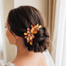 Charger l'image dans la galerie, Peigne de mariage aux feuilles dorées, cuivrées et bronze porté sur le côté d’un chignon bas brun de mariée.