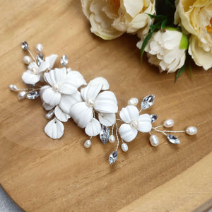 bijou de cheveux avec feuilles et fleurs blanches en argile polymère, perles naturelles d'eau douce et strass transparent pour chignon ou coiffure de mariage champêtre-chic