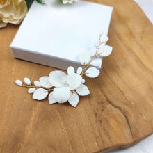 Charger l'image dans la galerie, Accessoire cheveux mariage Adora en porcelaine blanche avec fleur centrale et feuillage délicat doré.