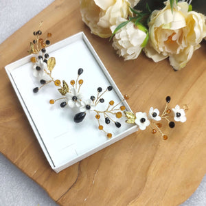 Accessoire de coiffure noir et doré orné de fleurs blanches, perles noires et cristaux couleur ambre.