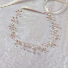 Charger l'image dans la galerie, Bandeau cheveux mariage doré avec perles ivoire présenté à plat sur fond clair texturé
