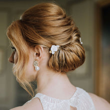 Charger l&#39;image dans la galerie, Barrette de mariage Zoé avec fleur blanche en porcelaine sur chignon bas élégant, bijou de cheveux artisanal.