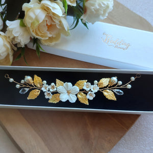 Vigne de cheveux pour coiffure de mariage en design floral avec perles, fleurs blanches et feuilles dorées