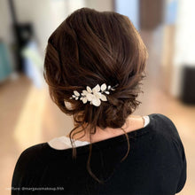 Charger l'image dans la galerie, Bijou de cheveux Adora en porcelaine blanche porté sur chignon bas souple, accessoire mariage artisanal élégant.