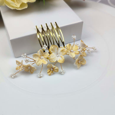 Peigne à cheveux discret mais lumineux avec petites fleurs en porcelaine froide en blanc et doré et branches de petites perles de rocaille blanches pour coiffure de mariage