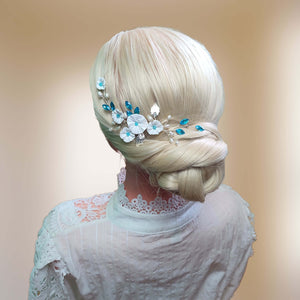 Ornement de cheveux avec fleurs blanches, feuilles argentées, perles naturelles et cristaux de strass bleu pour chignon de mariage