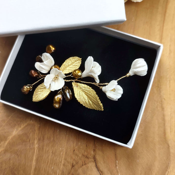 Petit bijou floral avec perles naturelles keshi bronze doré, fleurs nacrées et feuilles dorées en porcelaine froide pour coiffure de mariage ou soirée chic.