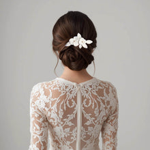 Charger l&#39;image dans la galerie, Bijou de cheveux mariage Karisa en porcelaine blanche porté sur un chignon bas, fleurs et feuilles modelées à la main.