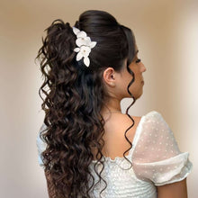 Charger l&#39;image dans la galerie, Bijou de cheveux Karisa en porcelaine blanche porté sur une coiffure mi-attachée bouclée, fleurs et feuilles faites main.