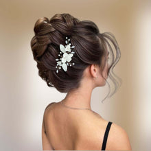 Charger l&#39;image dans la galerie, Bijou de cheveux Aliénor porté sur une coiffure tressée relevée, fleurs en porcelaine blanche, perles naturelles et strass brillants.