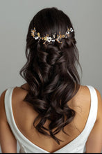 Charger l&#39;image dans la galerie, Accessoire de cheveux noir et doré avec fleurs blanches porté sur une demi-attache de mariée aux cheveux bouclés.