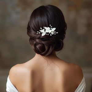 Bijou de cheveux Aliénor en porcelaine blanche avec perles et cristaux, porté sur un chignon bas élégant de mariée