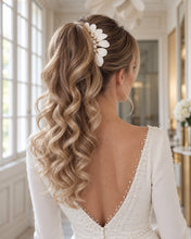 Charger l'image dans la galerie, Bijou de cheveux avec feuilles blanches en porcelaine froide, porté sur le côté d’une queue de cheval relevée de mariée aux cheveux blonds ondulés.