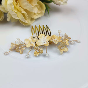 Peigne à cheveux discret mais lumineux avec petites fleurs en porcelaine froide en blanc et doré et branches de petites perles de rocaille blanches pour coiffure de mariage