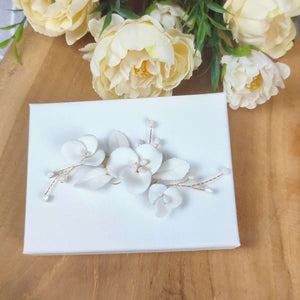 Bijou de cheveux floral avec fleurs et feuilles blanches en porcelaine froide et petites perles allongées en nacre pour coiffure ou chignon de mariage ou soirée