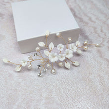 Charger l'image dans la galerie, Bijou de cheveux mariage fleurs blanches et perles avec branches finition dorée, présenté à plat sur fond clair.