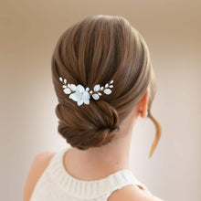 Charger l'image dans la galerie, Bijou de cheveux Adora en porcelaine blanche porté sur un chignon bas élégant, accessoire mariage raffiné fait main.