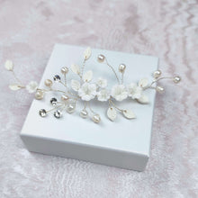 Charger l'image dans la galerie, Accessoire cheveux mariage floral avec fleurs blanches et perles, finition argentée, présenté sur support clair.