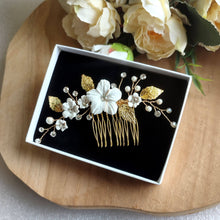 Charger l&#39;image dans la galerie, Bijou de cheveux Peigne avec fleurs blanches en porcelaine froide, perles, strass et feuilles dorées pour chignon de mariage bohème ou champêtre-chic