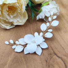 Charger l'image dans la galerie, Détail du bijou de cheveux Adora en porcelaine blanche avec fleur centrale et feuilles dorées, création artisanale pour mariée.