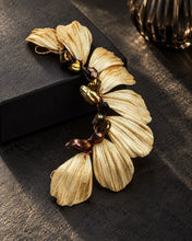 Charger l'image dans la galerie, Bijou de cheveux avec feuilles dorées et perles keshi marron, posée près d’une boîte noire.