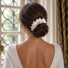 Charger l'image dans la galerie, Bijou de cheveux avec feuilles blanches en porcelaine froide et perles naturelles, porté autour d’un chignon bas de mariée.