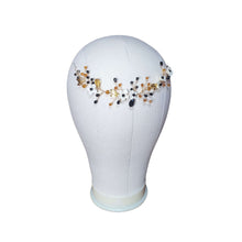 Charger l&#39;image dans la galerie, Bijou de tête noir et doré avec fleurs en porcelaine blanche, présenté sur un buste blanc.