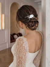 Charger l'image dans la galerie, Petit peigne floral blanc porté sur un chignon de mariée tressé, avec fleur en porcelaine et perles.