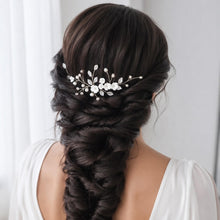 Charger l'image dans la galerie, Bijou de cheveux mariée avec fleurs, perles et feuilles argentées porté sur une longue tresse de mariage.