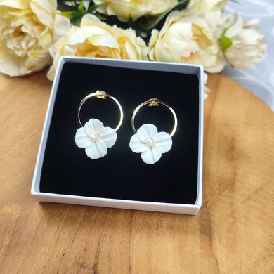 Boucles d'oreilles de mariage avec fleur blanche en porcelaine froide accroché sur un anneau à clou doré