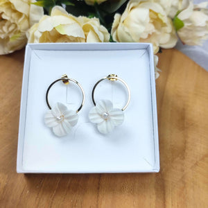 Boucles d'oreilles de mariage avec fleur blanche en porcelaine froide accroché sur un anneau à clou doré