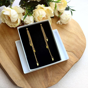 Boucles d'oreilles longues pendantes avec 3 petites feuilles dorées accrochées sur 3 chaînettes fines de différentes longueurs pour mariage bohème ou soirée