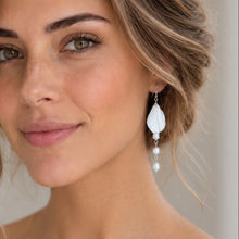 Charger l'image dans la galerie, Boucle d'oreille pendante de mariée avec feuille blanche en porcelaine froide et trois perles naturelles, portée par mariée romantique vue de près.