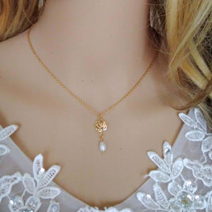 Collier minimaliste avec rose filigrane dorée et perles blanche en forme de goutte sur une fine chaîne dorée.