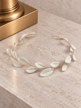 Charger l'image dans la galerie, Demi-couronne de mariage en feuilles blanches de porcelaine froide et fil doré présentée à plat sur un fond clair.