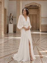 Charger l'image dans la galerie, Mariée en robe blanche portant une demi-couronne feuillage sur le front dans un intérieur élégant aux tons clairs.