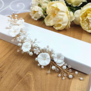 Bijou de cheveux Edora sur fond clair, détails des fleurs en porcelaine, perles et cristal.
