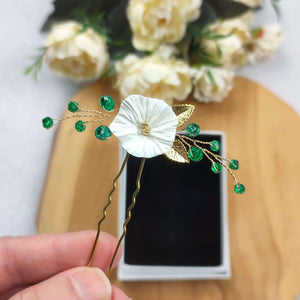 épingle à cheveux avec cristaux émeraude, feuilles dorées et fleur blanche en argile polymère pour coiffure de mariage ou soirée