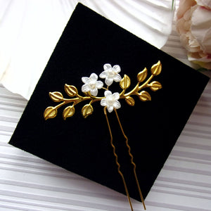 petit bijou de cheveux style rustique avec 2 branches de feuilles dorées et 3 petites fleurs monté sur une épingle à chignon