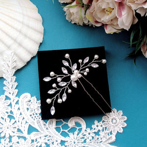 Bijou de cheveux en feuilles de strass transparent et perles nacrées monté sur une épingle à chignon pour coiffure de mariage ou soirée
