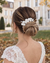 Charger l'image dans la galerie, Épingles à cheveux en fleurs blanches et perles naturelles, disposées au-dessus d’un chignon bas de mariée.