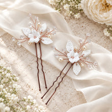 Charger l'image dans la galerie, Deux épingles aux finitions or rose, avec fleurs et feuilles blanches en porcelaine froide, perles naturelles et cristaux transparents, présentées à plat