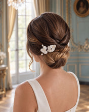 Charger l'image dans la galerie, Épingles à fleurs blanches et perles portées au-dessus d’un chignon bas de mariée, vue de profil.