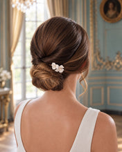 Charger l'image dans la galerie, Épingle solitaire à 2 fleurs blanches portée au-dessus d’un chignon bas de mariée, vue de profil.