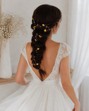 Charger l'image dans la galerie, Fine vigne de cheveux bohème romantique avec feuilles dorées et perles , portée par une mariée aux cheveux bruns sur longue tresse. Vue de dos.