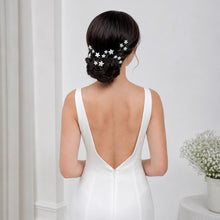 Charger l'image dans la galerie, Vue de dos d’une mariée portant des épingles étoiles blanches autour d’un chignon bas travaillé.